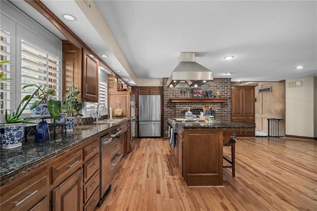 3705 W 119th Ter, Leawood, KS 66209 - kitchen with freestanding refrigerator, a sink, a breakfast bar area, wall chimney range hood, and light wood-style flooring
