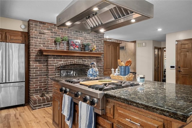 3705 W 119th Ter, Leawood, KS 66209 - kitchen featuring freestanding refrigerator, wall chimney range hood, light wood finished floors, brown cabinetry, and recessed lighting