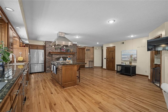 3705 W 119th Ter, Leawood, KS 66209 - kitchen featuring appliances with stainless steel finishes, exhaust hood, a kitchen breakfast bar, light wood-style flooring, and a sink