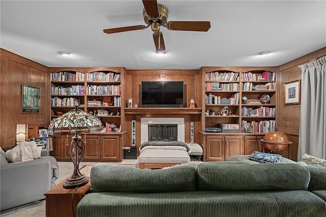 3705 W 119th Ter, Leawood, KS 66209 - carpeted living room featuring wood walls, ceiling fan, a fireplace, and built in shelves