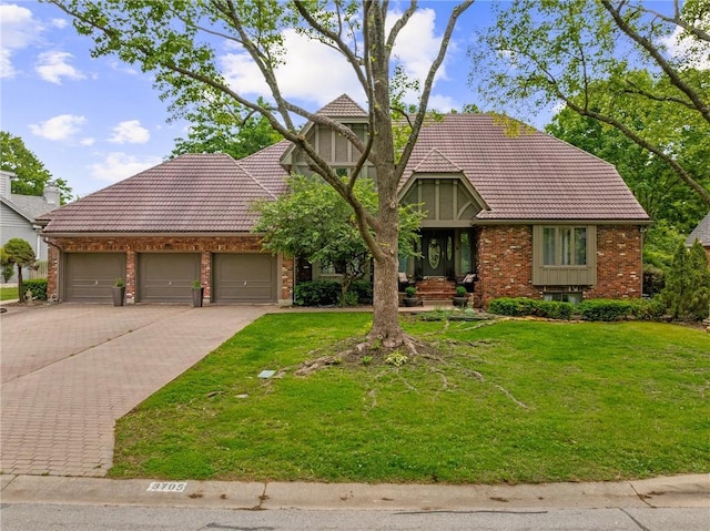 3705 W 119th Ter, Leawood, KS 66209 - tudor home featuring a tiled roof, brick siding, driveway, and a front yard