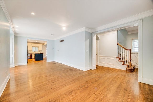 unfurnished living room featuring visible vents, ornamental molding, stairs, light wood-style floors, and recessed lighting