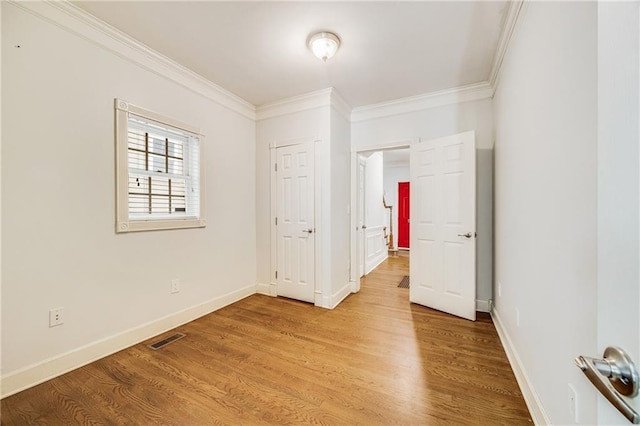 unfurnished bedroom featuring ornamental molding, light wood-style flooring, and visible vents