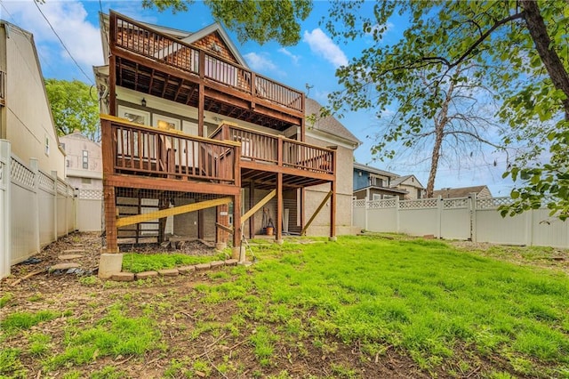 back of property featuring a fenced backyard, a wooden deck, and a yard