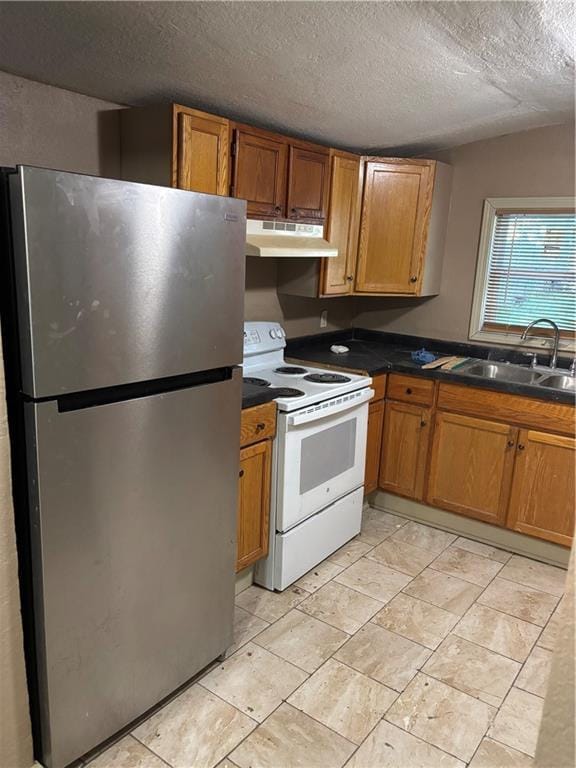 6941 Spruce Ave, Kansas City, MO 64132 - kitchen with freestanding refrigerator, electric stove, under cabinet range hood, dark countertops, and brown cabinetry