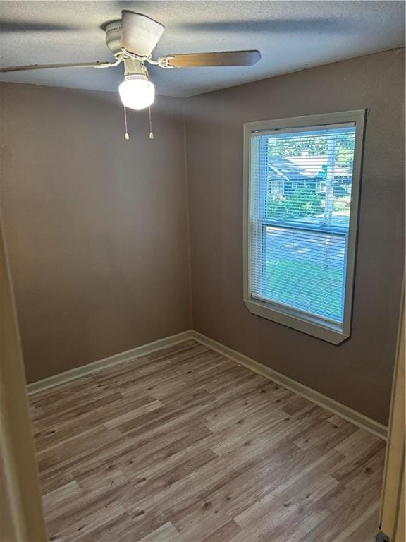 6941 Spruce Ave, Kansas City, MO 64132 - spare room featuring light wood-style floors, ceiling fan, and a textured ceiling