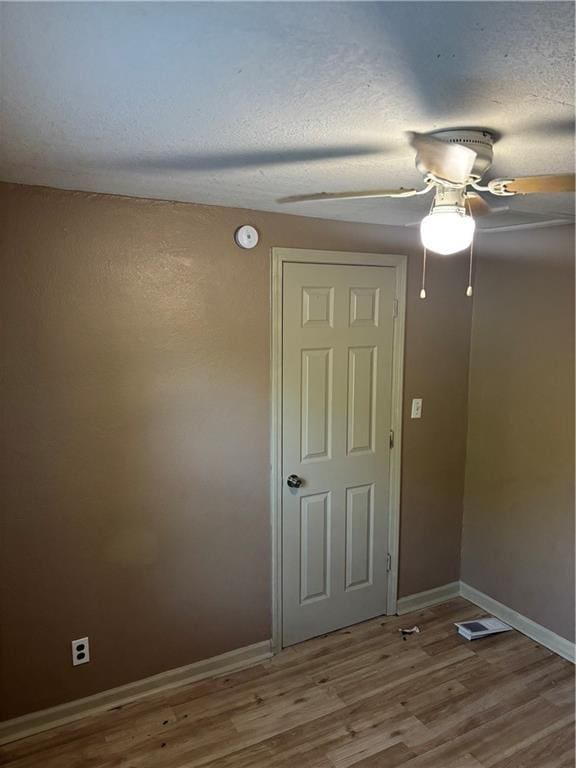 6941 Spruce Ave, Kansas City, MO 64132 - empty room featuring ceiling fan, wood finished floors, a textured ceiling, and a smoke detector