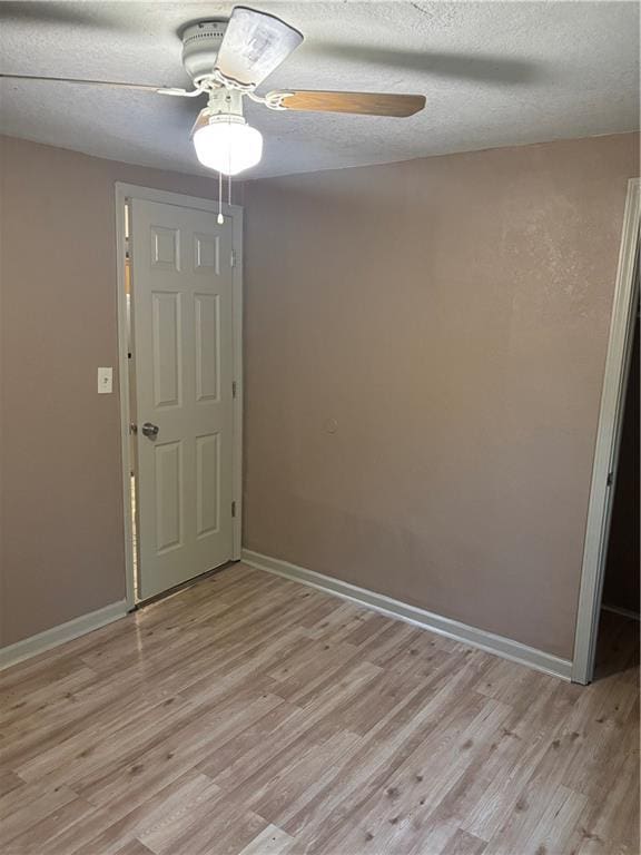 6941 Spruce Ave, Kansas City, MO 64132 - unfurnished room with light wood-style flooring, a ceiling fan, and a textured ceiling