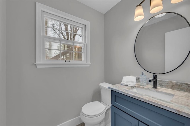 bathroom with baseboards, toilet, and vanity