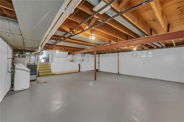 basement featuring water heater and stairs