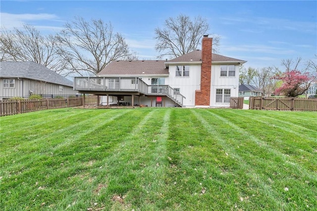back of property with stairs, a fenced backyard, a yard, and a chimney