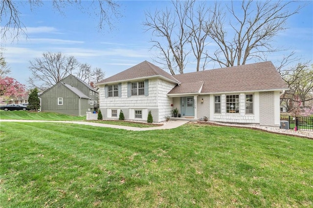 split level home with central air condition unit, a front yard, and fence