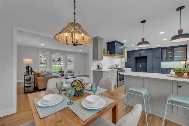 dining room featuring baseboards, an inviting chandelier, recessed lighting, and light wood-type flooring