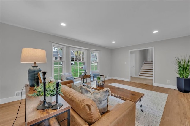 living room with baseboards, stairs, recessed lighting, and light wood-type flooring