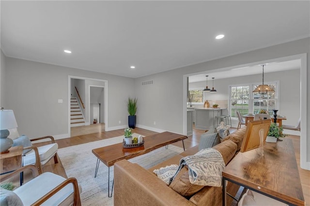 living room with recessed lighting, light wood-style floors, stairway, and visible vents