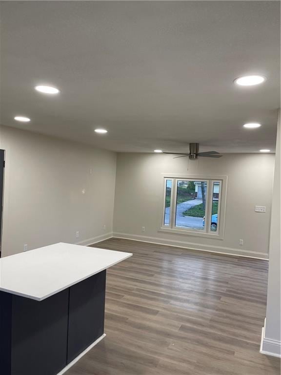 empty room with baseboards, recessed lighting, wood finished floors, and a ceiling fan