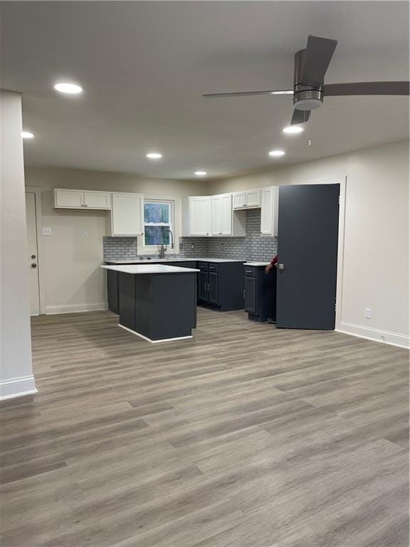 kitchen featuring white cabinets, recessed lighting, light wood-style flooring, and baseboards