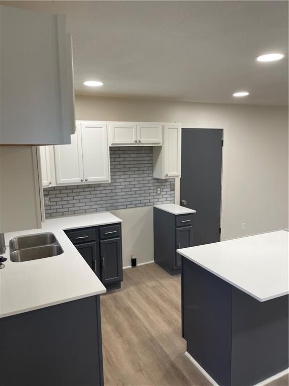 kitchen featuring recessed lighting, tasteful backsplash, light wood-style flooring, and white cabinetry