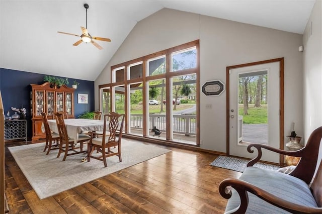 dining area with ceiling fan, hardwood / wood-style flooring, and high vaulted ceiling