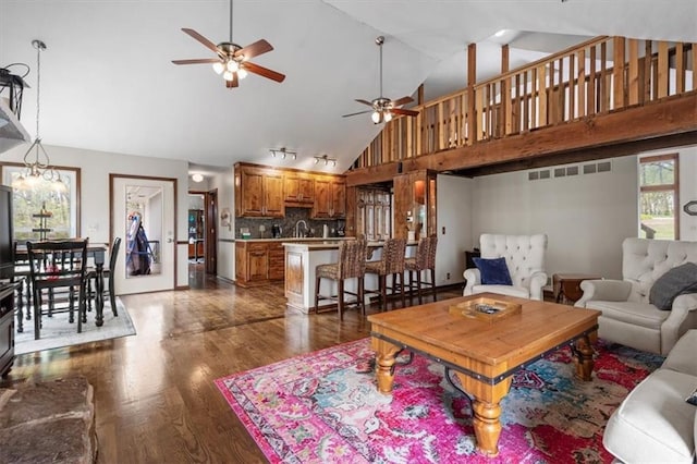living area featuring ceiling fan, high vaulted ceiling, and dark wood-type flooring