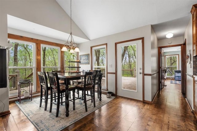 dining area with vaulted ceiling, hardwood / wood-style flooring, and baseboards