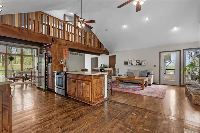 kitchen featuring a healthy amount of sunlight, appliances with stainless steel finishes, ceiling fan, high vaulted ceiling, and open floor plan