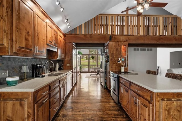 kitchen featuring stainless steel appliances, ceiling fan, a sink, dark wood-style floors, and high vaulted ceiling
