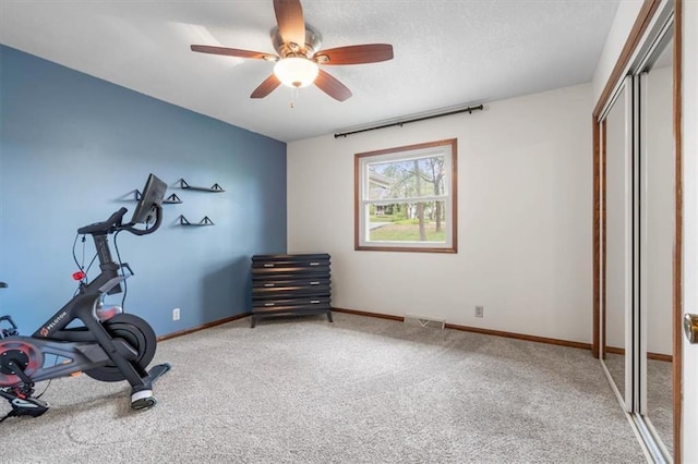 exercise room with baseboards, visible vents, ceiling fan, and carpet floors