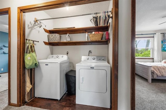 laundry room with dark carpet, washing machine and clothes dryer, and a textured ceiling