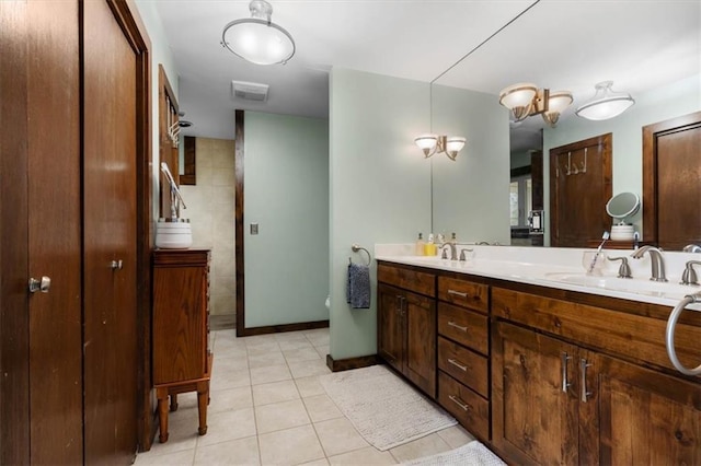 bathroom with tile patterned floors, a sink, visible vents, and double vanity