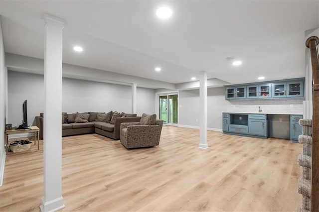 living room featuring light wood-style floors, bar, recessed lighting, and baseboards