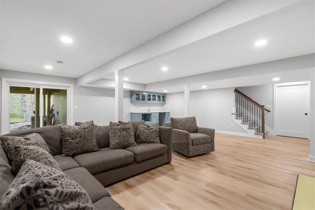living room with baseboards, bar area, light wood-type flooring, recessed lighting, and stairs