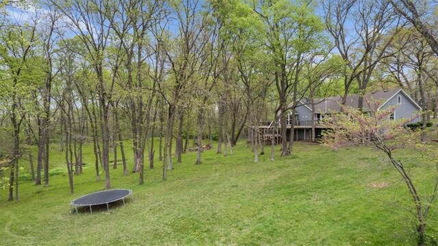 view of yard with a deck and a trampoline