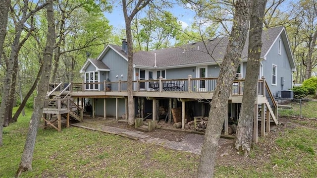 rear view of house featuring a deck, stairs, and a chimney