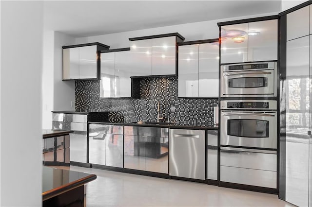 11273 S Lakecrest Dr, Olathe, KS 66061 - kitchen with appliances with stainless steel finishes, a sink, white cabinets, backsplash, and modern cabinets