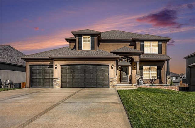 view of front of house with a yard, an attached garage, stone siding, and driveway