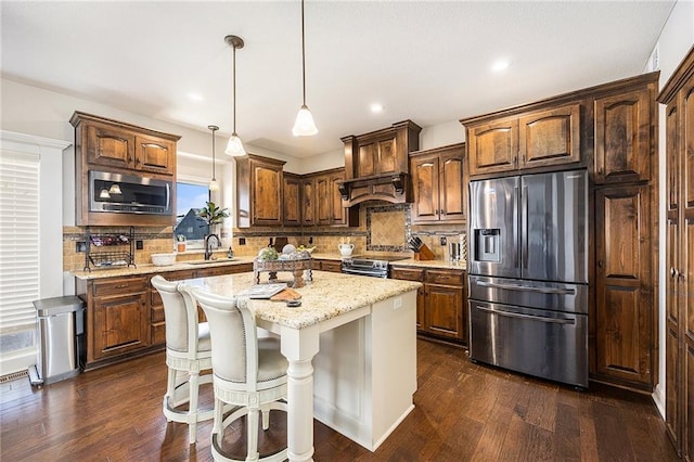 kitchen with a sink, tasteful backsplash, dark wood finished floors, custom exhaust hood, and appliances with stainless steel finishes