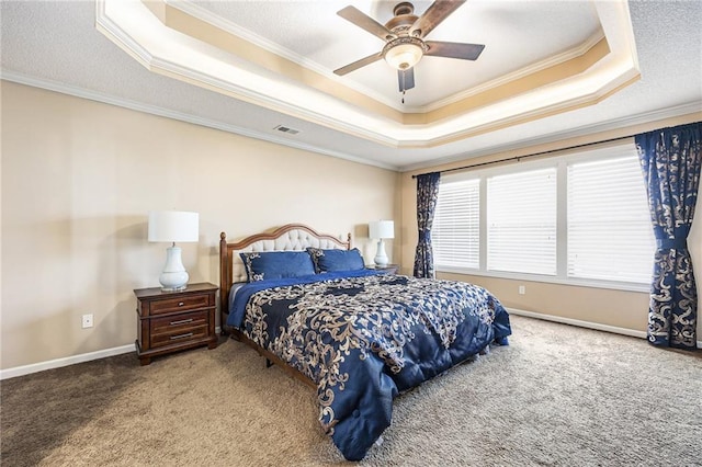 bedroom with a tray ceiling, visible vents, baseboards, crown molding, and carpet floors