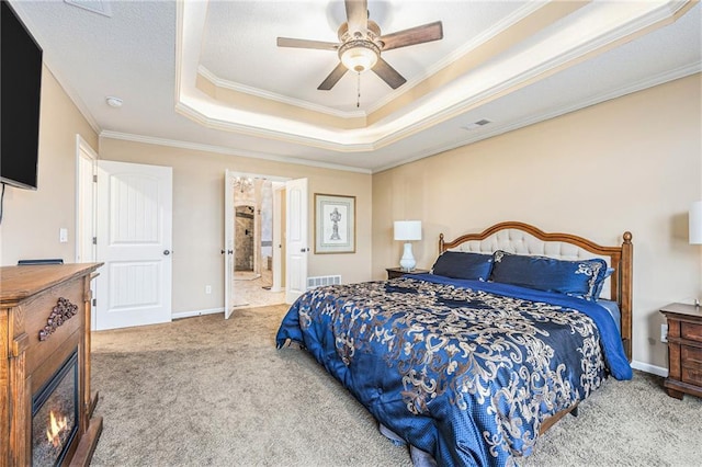 bedroom featuring a raised ceiling, visible vents, carpet flooring, and ornamental molding