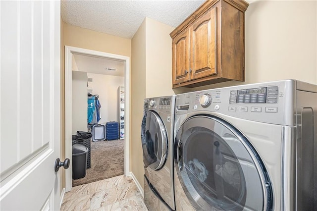 washroom featuring marble finish floor, visible vents, washer and dryer, cabinet space, and a textured ceiling