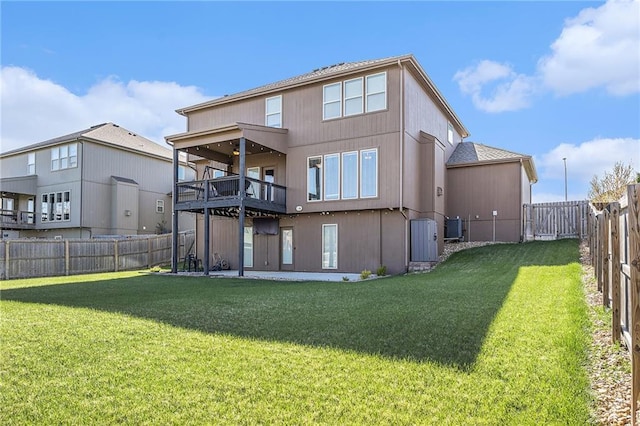 back of house with a yard and a fenced backyard