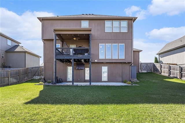back of property with a fenced backyard, a balcony, a yard, and a patio