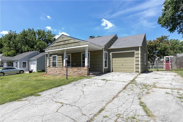 1306 W 29th St S, Independence, MO 64052 - view of front of house with a garage, driveway, stone siding, and a porch