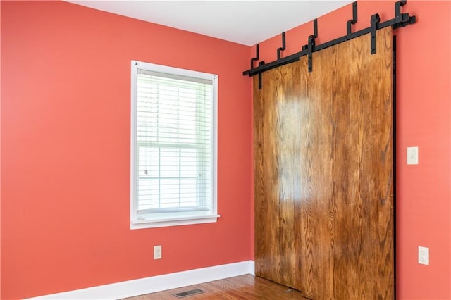 1306 W 29th St S, Independence, MO 64052 - unfurnished room featuring wood finished floors and a barn door