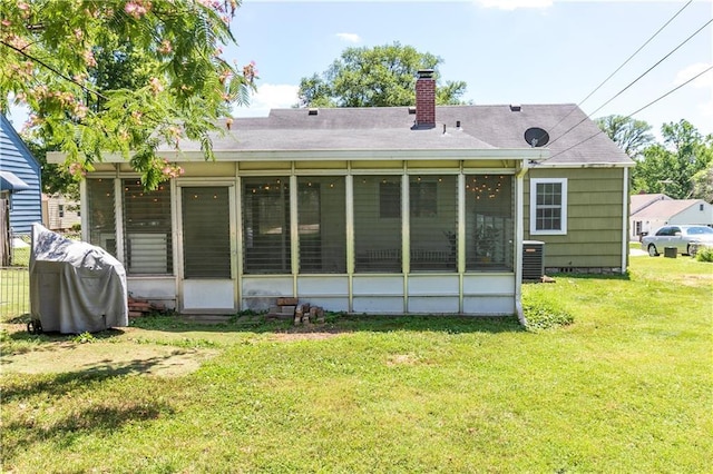 1306 W 29th St S, Independence, MO 64052 - back of property featuring a sunroom, a chimney, a yard, and a shingled roof