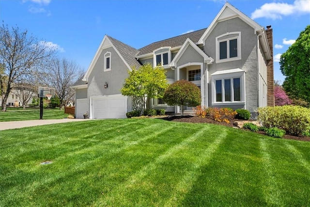 view of front of house with driveway, a shingled roof, a front lawn, and stucco siding