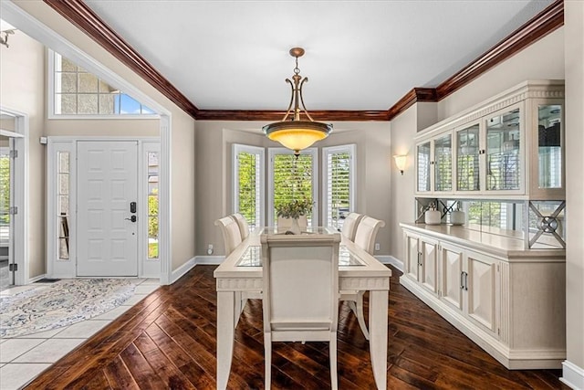 dining room with baseboards, ornamental molding, and dark wood-type flooring