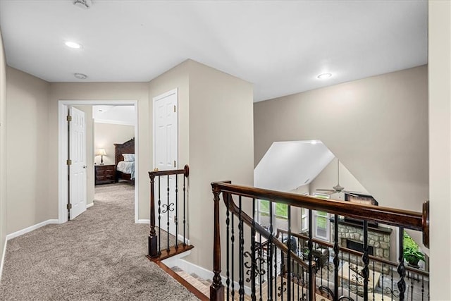 hallway with recessed lighting, carpet floors, baseboards, and an upstairs landing