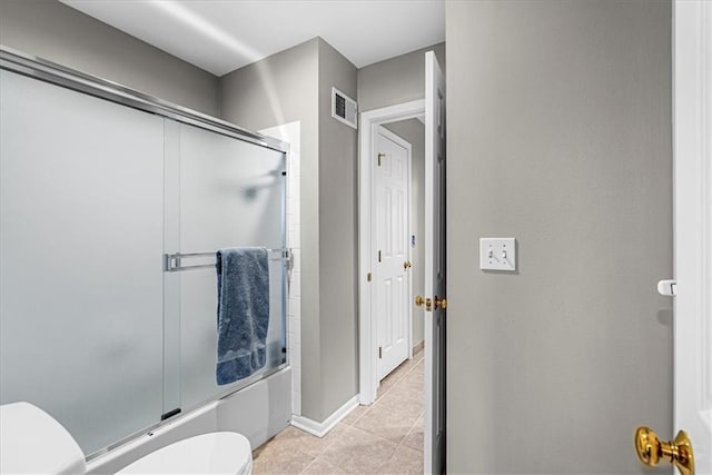 bathroom with shower / bath combination with glass door, tile patterned flooring, visible vents, toilet, and baseboards