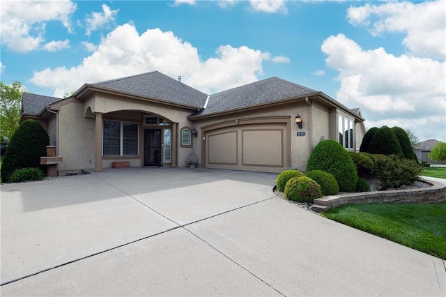 ranch-style house featuring stucco siding, driveway, roof with shingles, and a garage